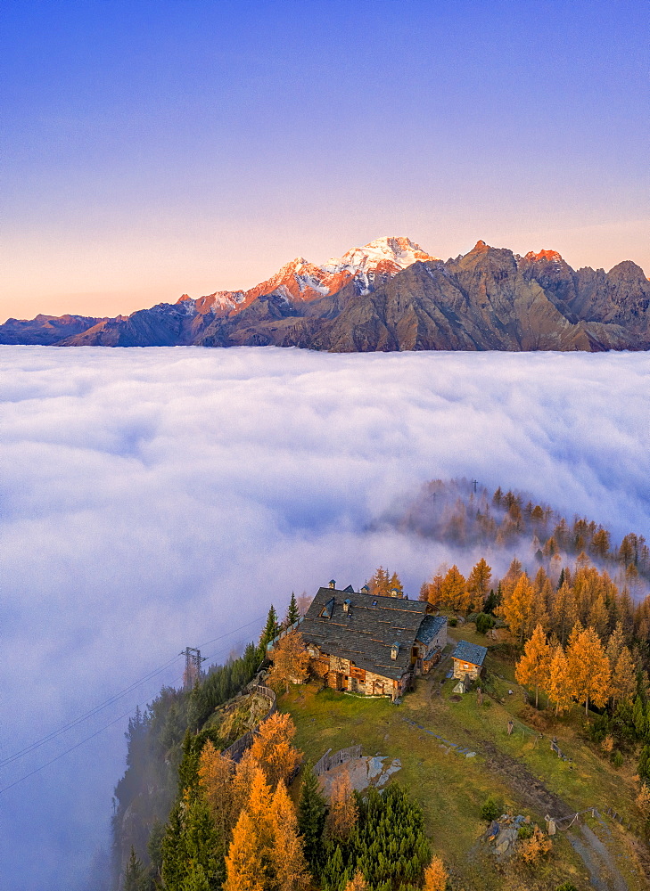 Fog covers the Valmalenco (Val Malenco) with Mount Disgrazia illuminated by sunrise and the Motta hut, Valtellina, Lombardy, Italy, Europe