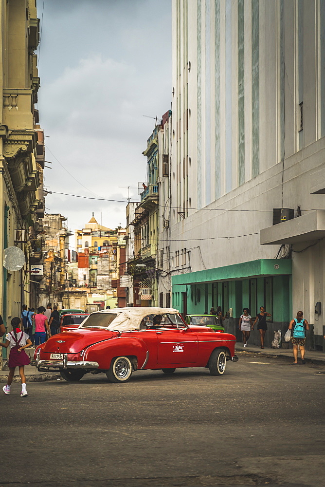 Red vintage car turning in streets of La Habana (Havana), Cuba, West Indies, Caribbean, Central America