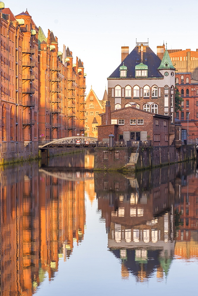 Wasserschloss building at the historical warehouse complex (Speicherstadt) seen from Poggenmuehlenbruecke at sunrise, Hamburg, Germany, Europe