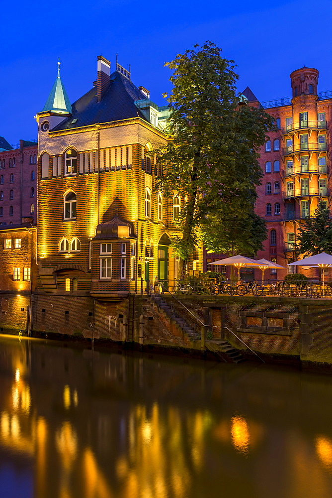 Illuminated Wasserschlosschen building in the historical Speicherstadt (Warehouse Complex) at dusk, Hamburg, Germany, Europe