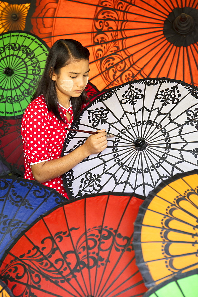 Young lady decorates colourful parasols in Bagan (Pagan), Myanmar (Burma), Asia