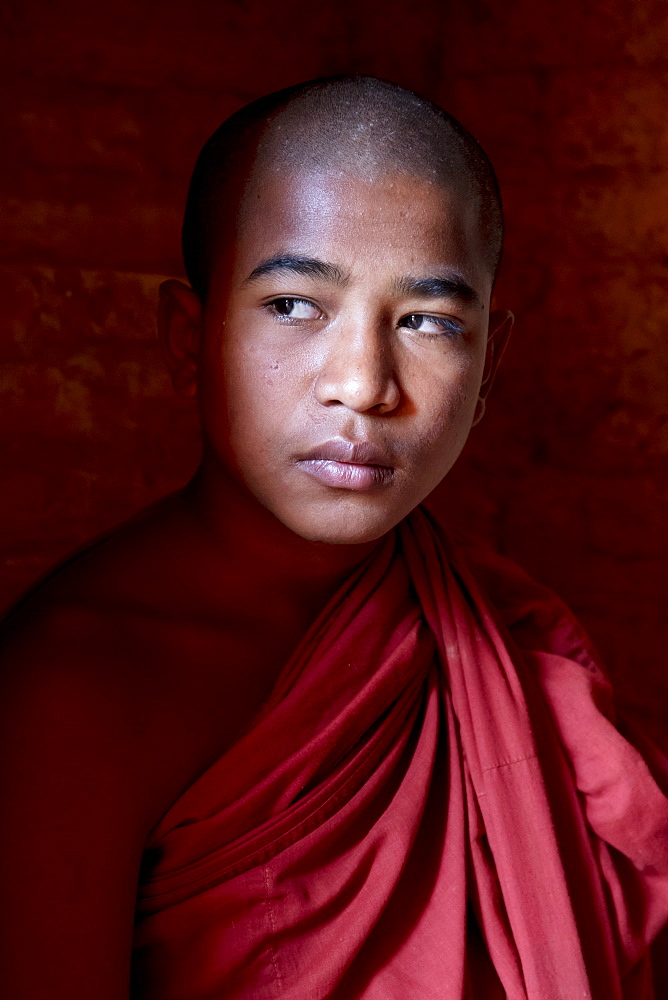 Young monk in the shadows at a temple in Bagan, Myanmar (Burma), Asia