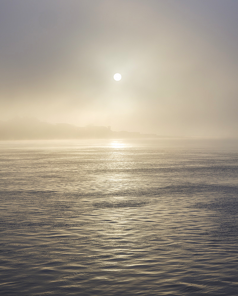 The sun shines through heavy fog on the sea front at Exmouth, Devon, England, United Kingdom, Europe