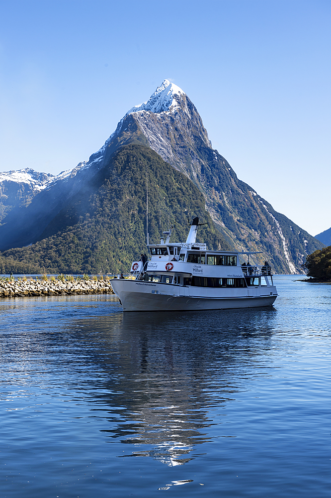 Milford Adventurer Cruise ship at Milford Sound with snow capped Mitre Peak, Fiordland National Park, UNESCO World Heritage Site, South Island, New Zealand, Pacific