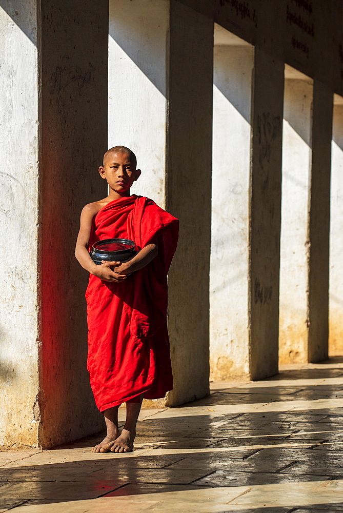 Novice Buddhist monk holding a bowl in Shwezigon Pagoda in Nyaung U, Bagan (Pagan), Myanmar (Burma), Asia