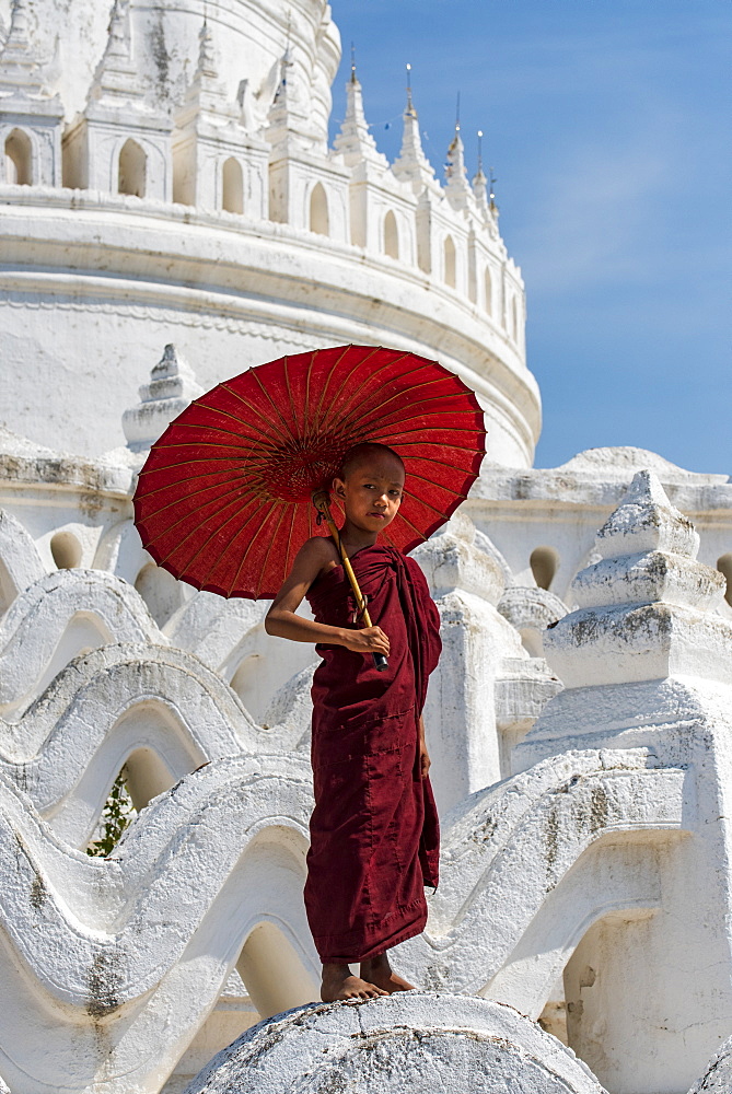 Young novice Buddhist monk standing on temple walls, Mingun, Saigang, Myanmar (Burma), Asia