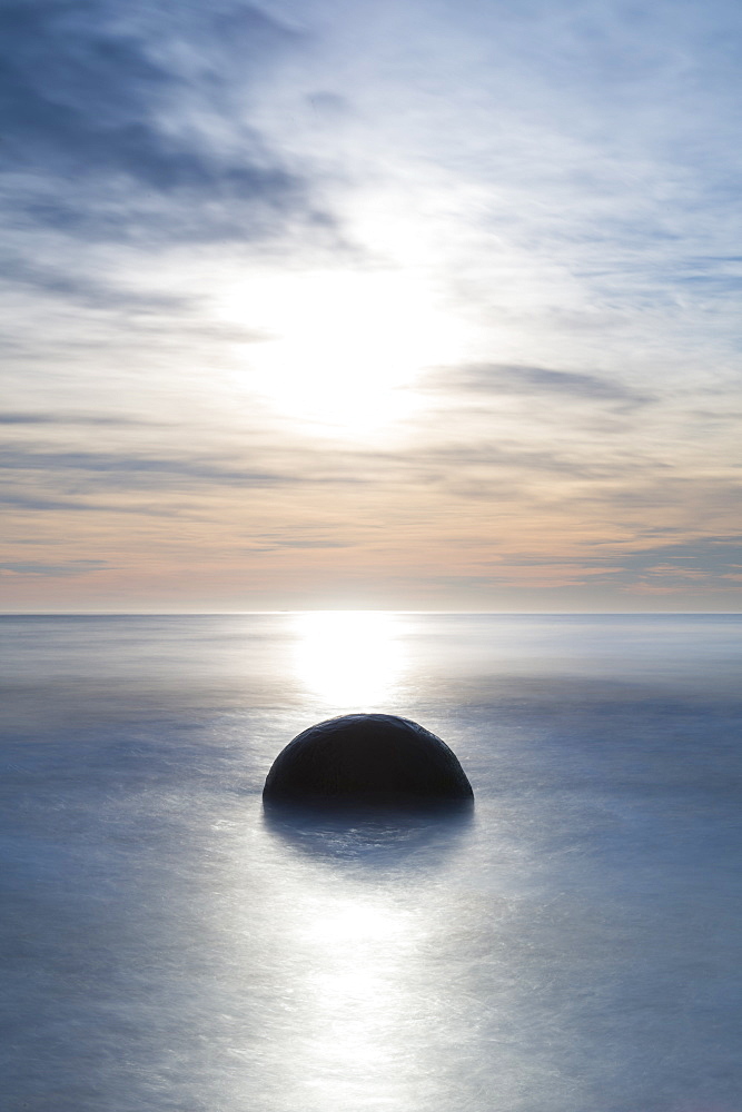 A single Moeraki Boulder at sunrise with long exposure, Moeraki Beach, Otago, South Island, New Zealand, Pacific