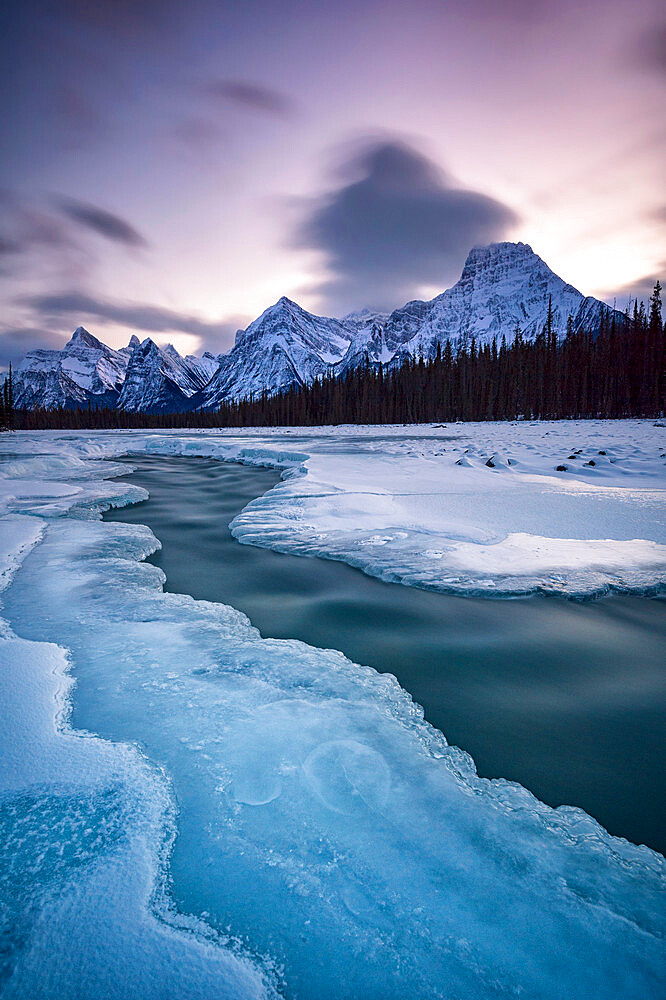 The Athabasca River in winter with mountain backdrop, Alberta, Canada, North America