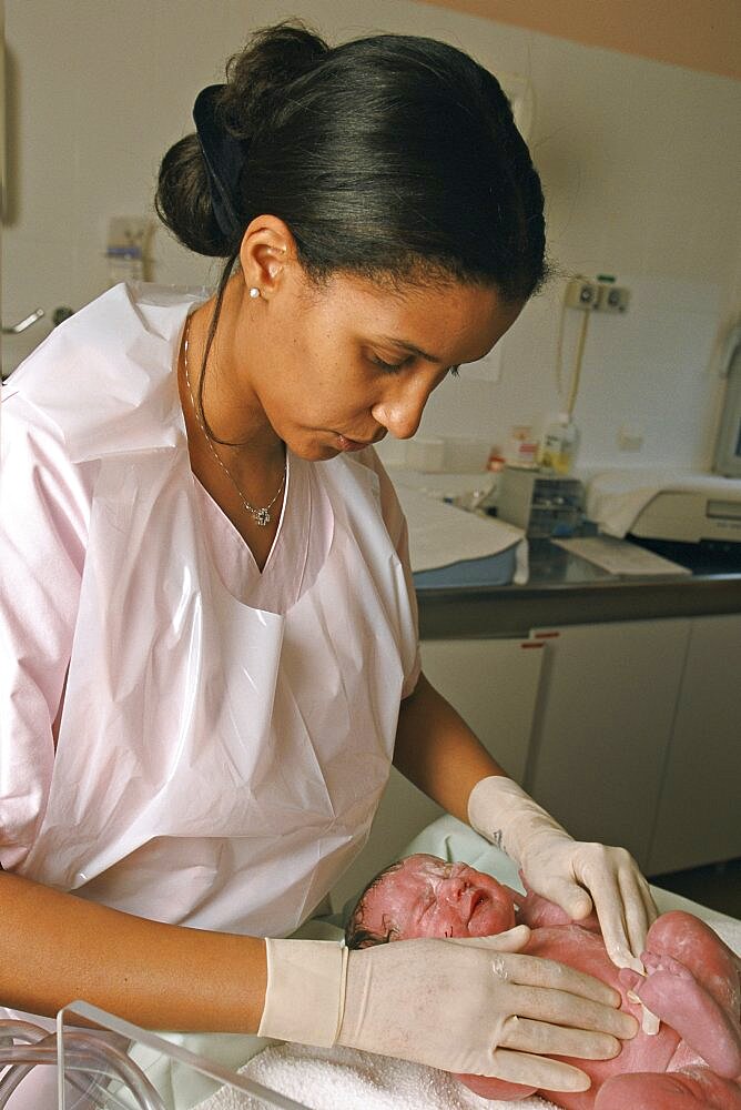 Midwife In Maternity Ward, Examining Newborn