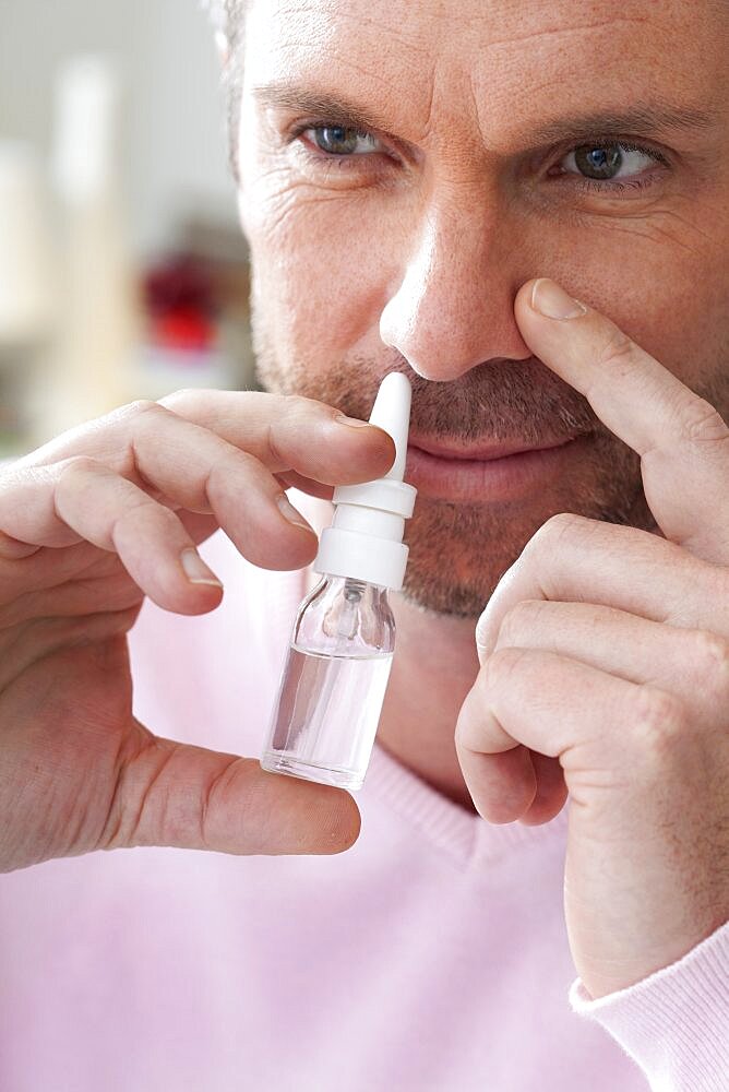 Mature man using nasal spray