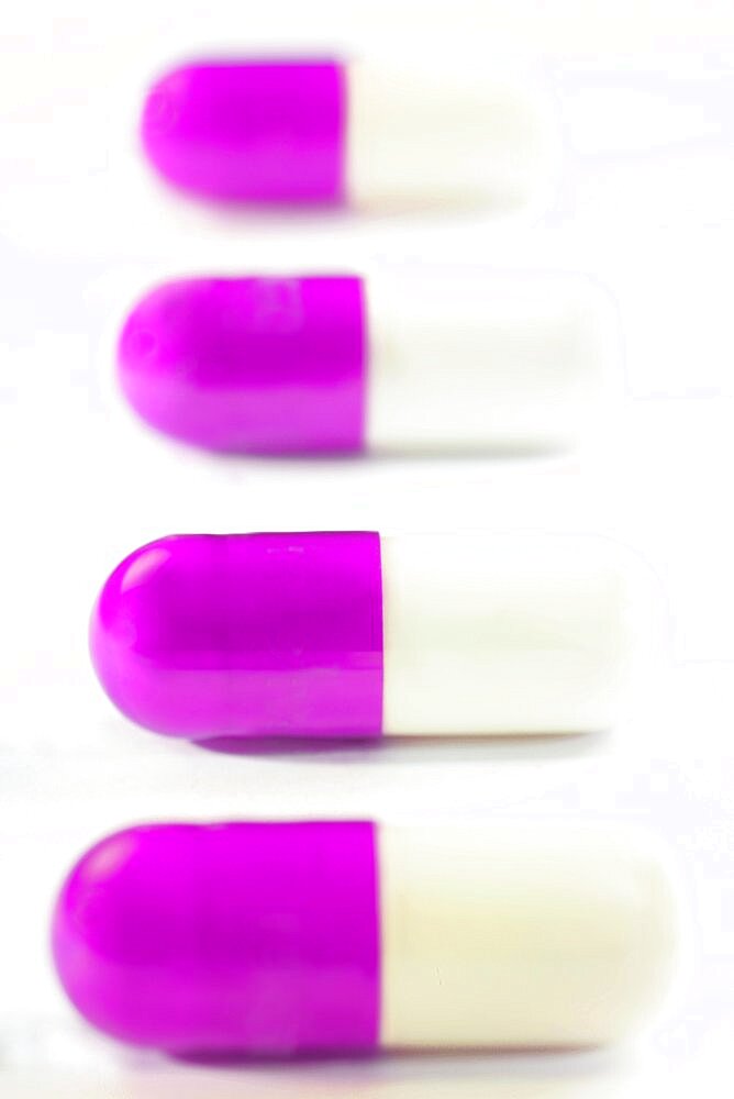 Four purple and white pills