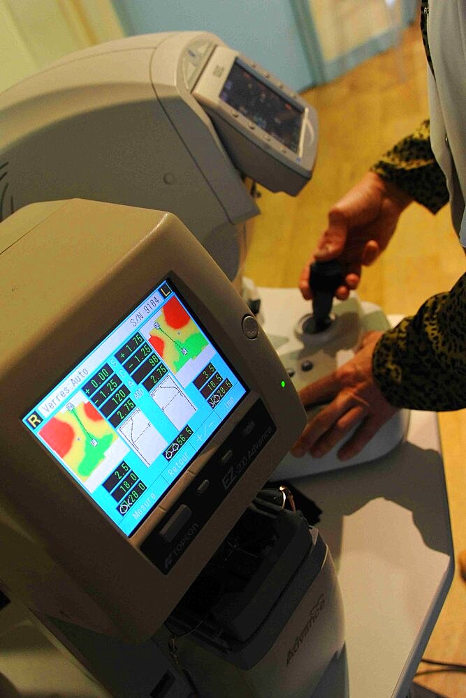 Ophthalmology office. Refractometer, a device for measuring refractive indices. Masked patient and doctor - Covid 19.