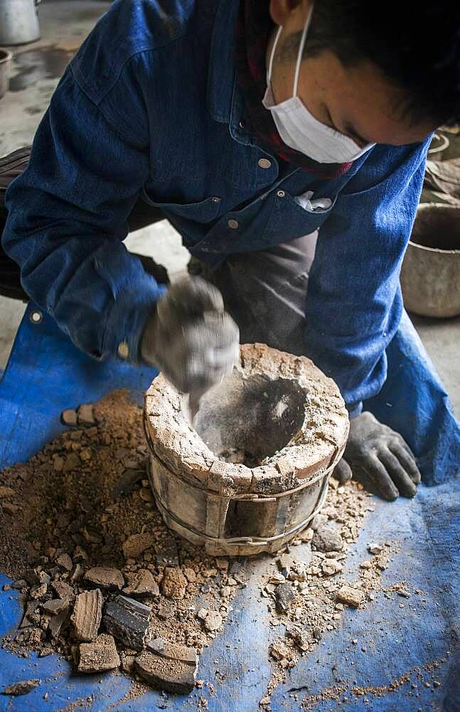 Kohei ishimori is clearing a outer mold for make a new design of a iron teapot or tetsubin, nanbu tekki,Workshop of Koizumi family,craftsmen since 1659, Morioka, Iwate Prefecture, Japan