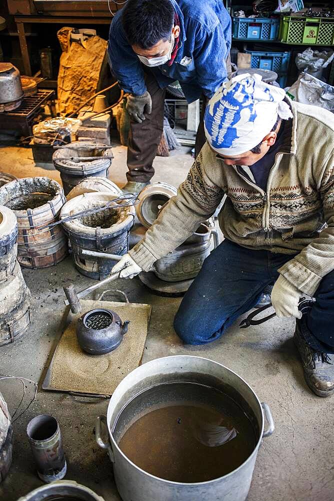 This is an important moment in the construction process. They are checking that no water escapes from the new iron teapot or tetsubin, nanbu tekki,Workshop of Koizumi family,craftsmen since 1659, Morioka, Iwate Prefecture, Japan