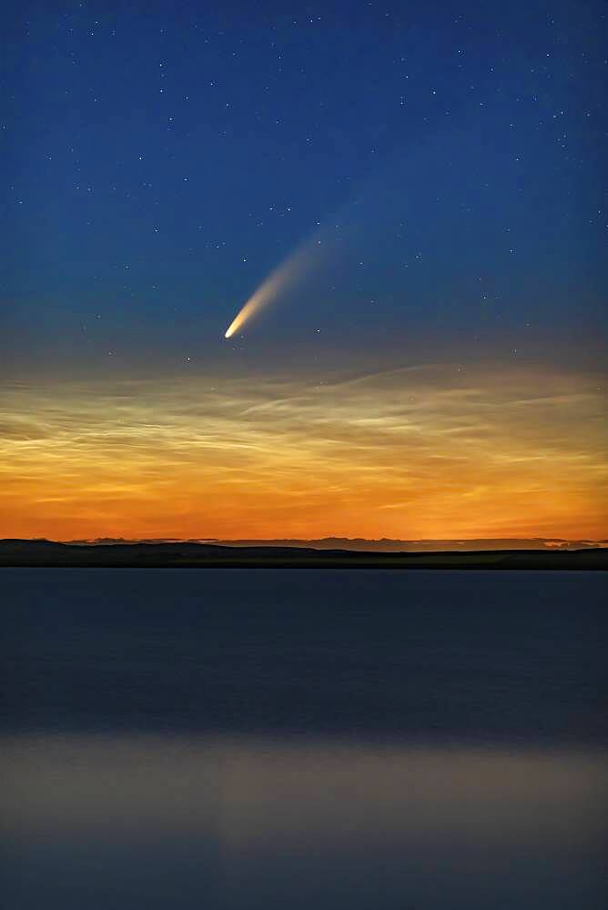 This is Comet NEOWISE (C/2020 F3) over Deadhorse Lake near Hussar in southern Alberta, taken just after midnight on July 10-11, 2020 during its evening appearance. The comet shines just above low noctilucent clouds. The slight wind ruffled the waters enough to prevent the clean reflection I was after.