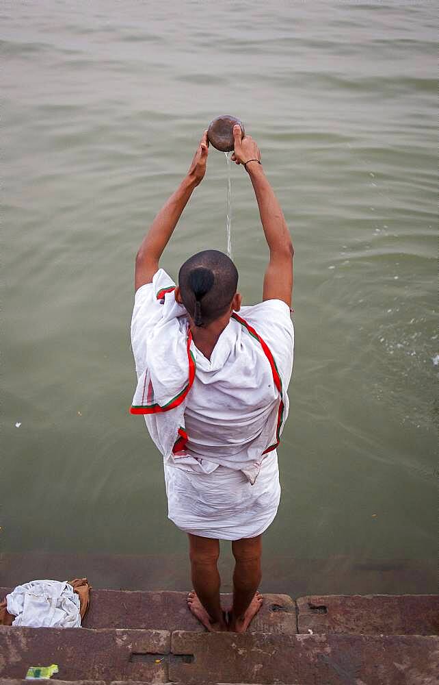 A man praying, in the ghats of Ganges river, Varanasi, Uttar Pradesh, India.