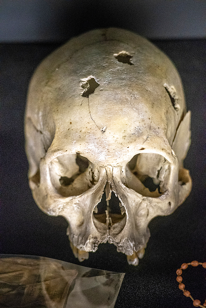 Damaged skulls of known victims of the 1994 Rwandan Genocide remain interred inside of of the Kigali Genocide Memorial as a testament to those lost in the brutality, Kigali, Rwanda.