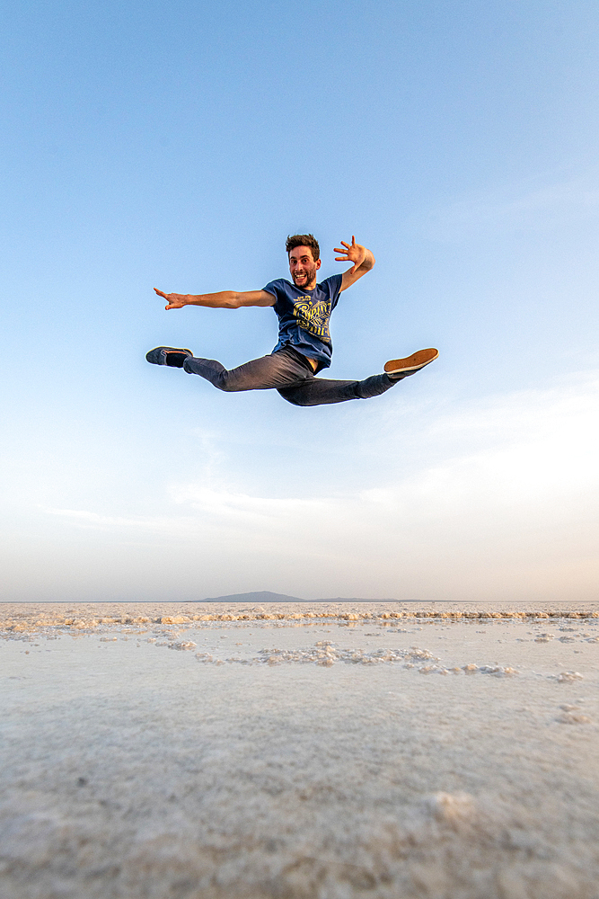 A man leaps and dances in the middle of salt flats Danakil Depression, Ethiopia