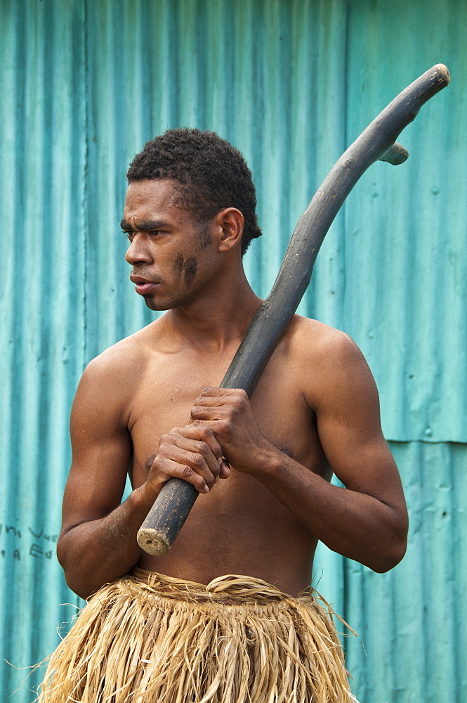 Inosi Navoto with warrior club greeting visitors to Lawai Pottery Village on Viti Levu Island, Fiji.