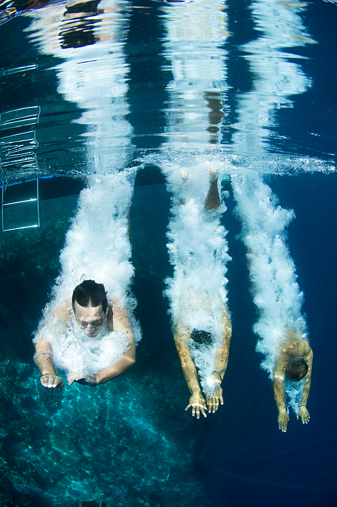 Three people jump into the water at the same time, Bunaken National Park, Manado, North Sulawesi, Indonesia, Pacific Ocean