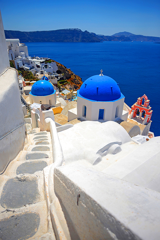 Hillside buildings with traditional church blue domes in Oia, Santorini, Greek Islands, Greece