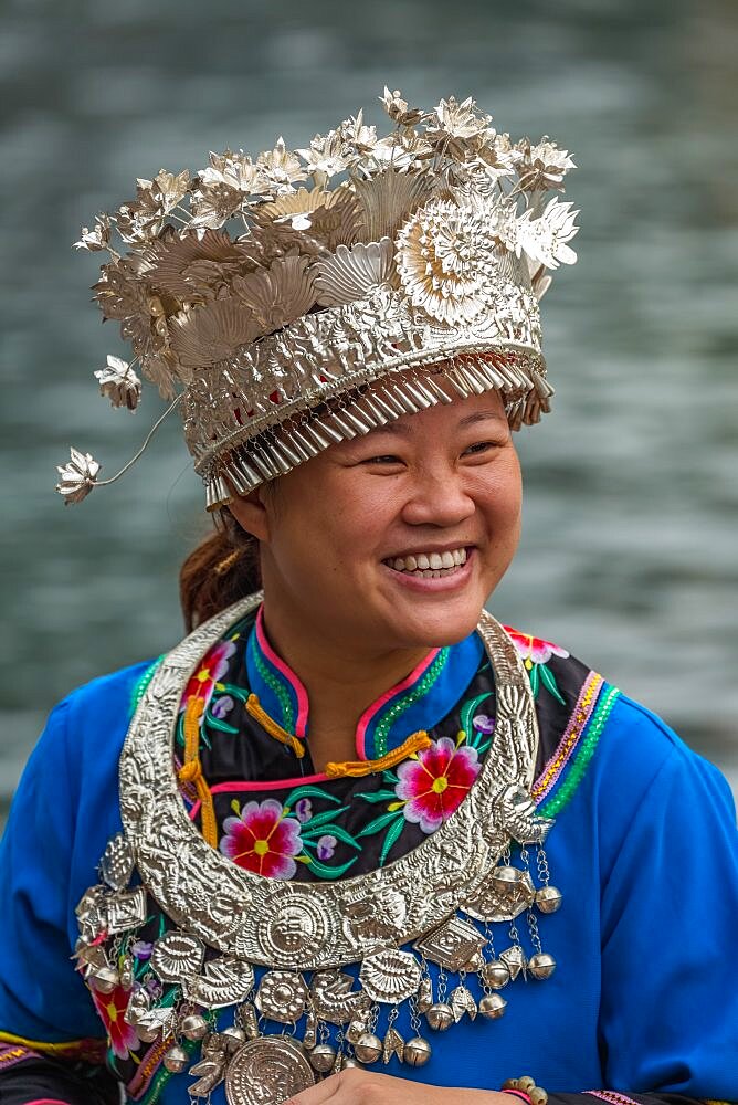 A young woman poses in the traditional ceremonial dress of the MIao ethnic minority in Fenghuang, China.