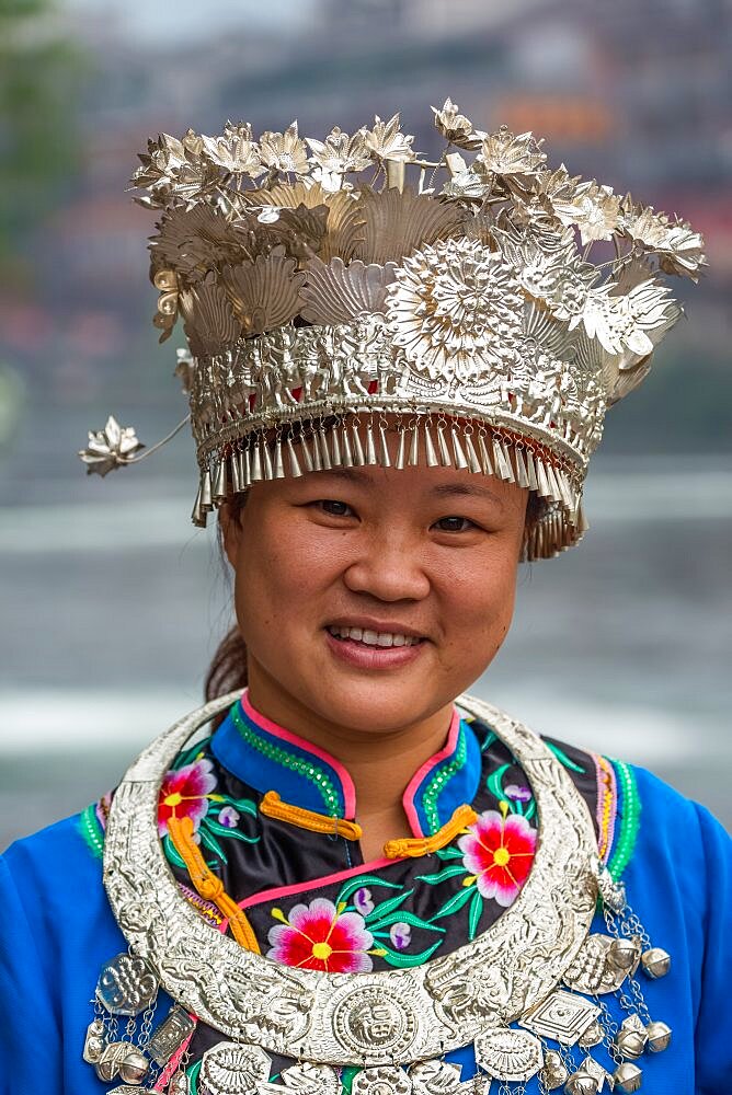 A young woman poses in the traditional ceremonial dress of the MIao ethnic minority in Fenghuang, China.