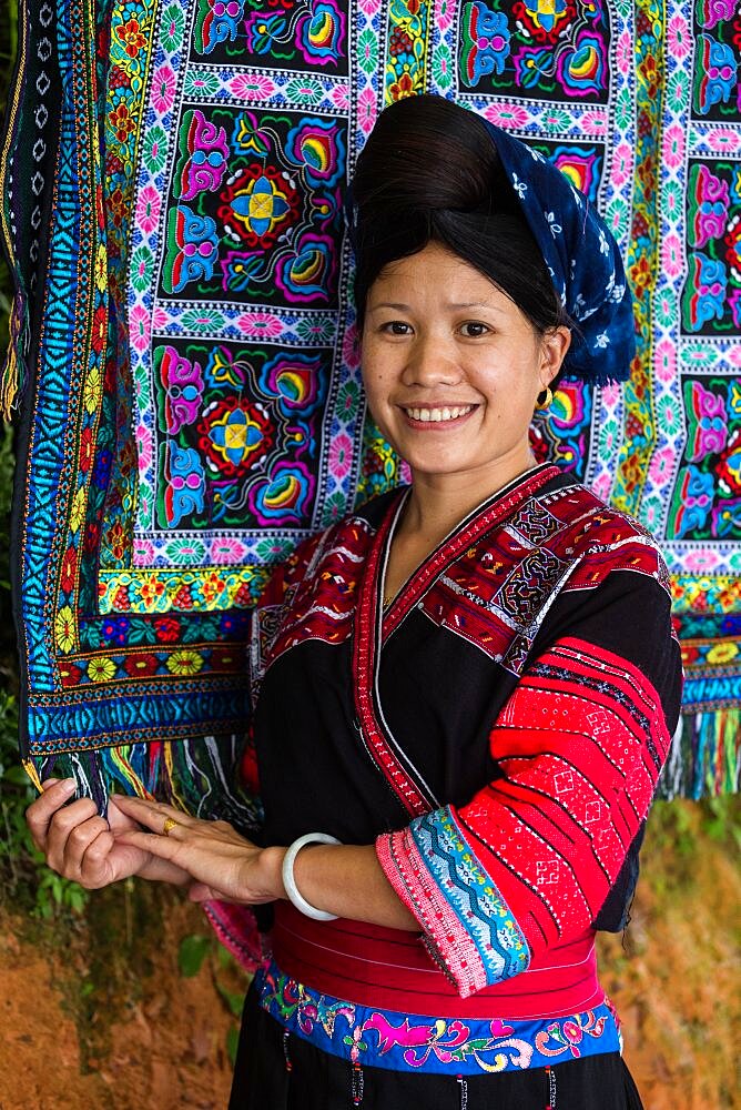 A woman of the Red Yao ethnic minority sells traditional hand-woven fabrics in Ping'an, China.