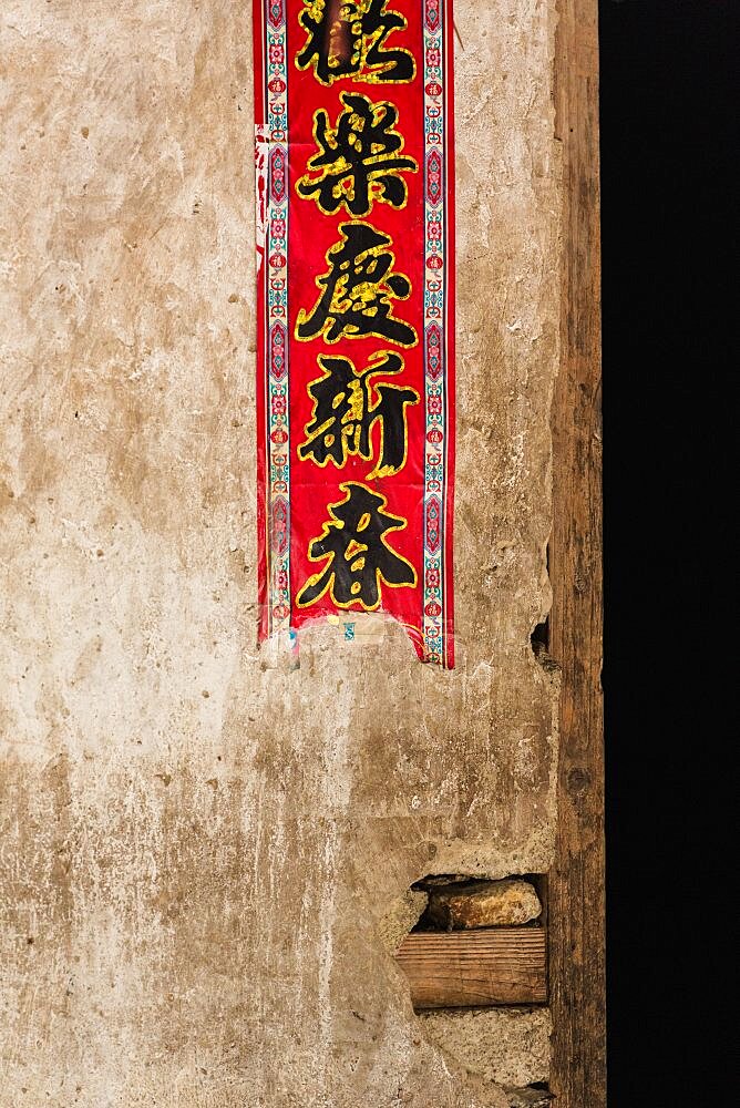 Detail of a banner on the wall of a traditional house in the Red Yao village of Huangluo, China.