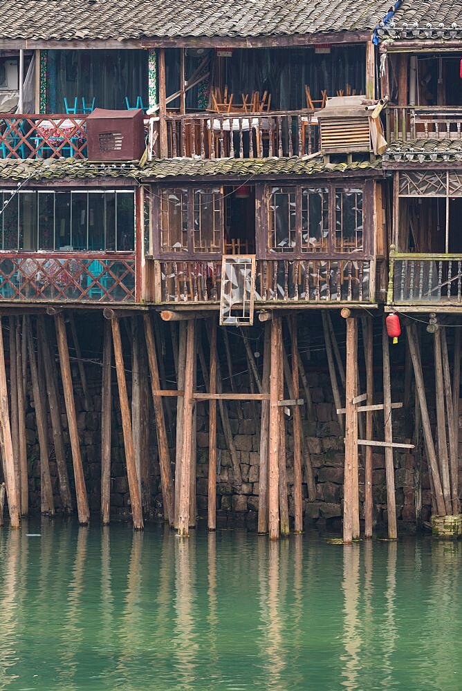 Traditional Diaojiao houses on stilts along the banks of the Tuojiang River. Ancient town of Fenghuang, China.