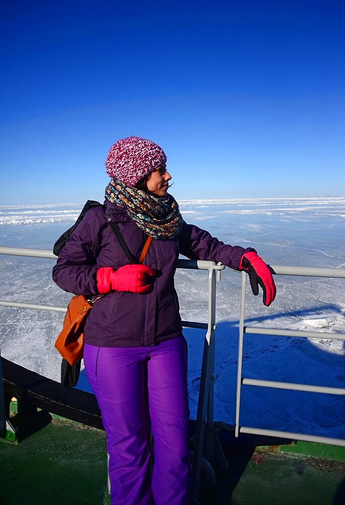 Young woman enjoying Sampo Icebreaker cruise, an authentic Finnish icebreaker turned into touristic attraction in Kemi, Lapland