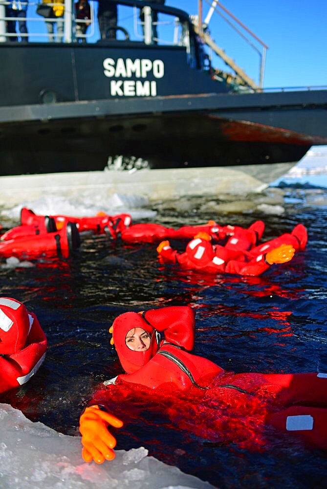 Young woman swimming in the frozen sea during Sampo Icebreaker cruise, an authentic Finnish icebreaker turned into touristic attraction in Kemi, Lapland