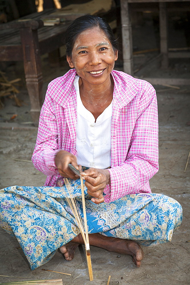 Woman splitting bamboo to make a fan, Yay Kyi village, Mandalay, Myanmar, (Burma)