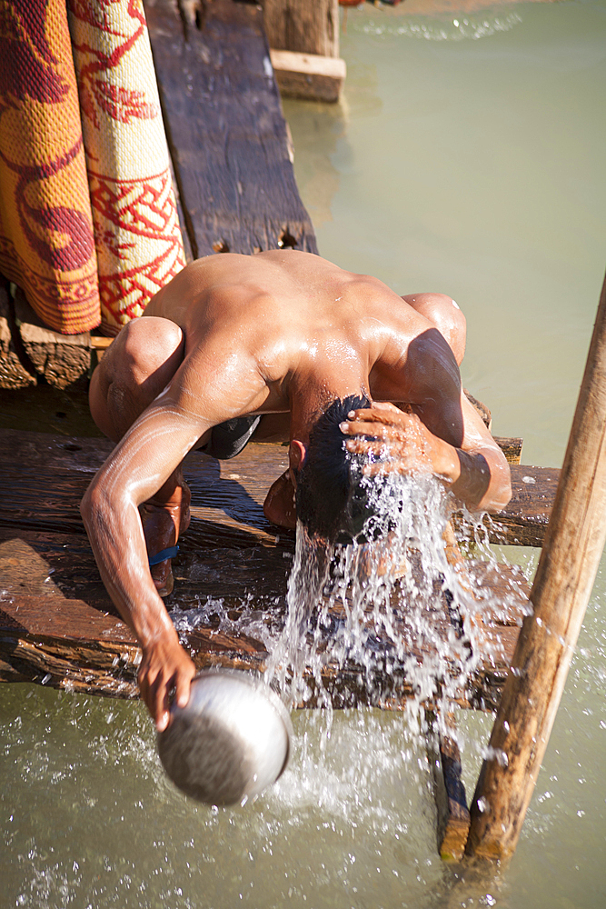 Man washing himself beside Inle Lake, Indein Village, near Taunggyi, Shan State, Myanmar, (Burma)