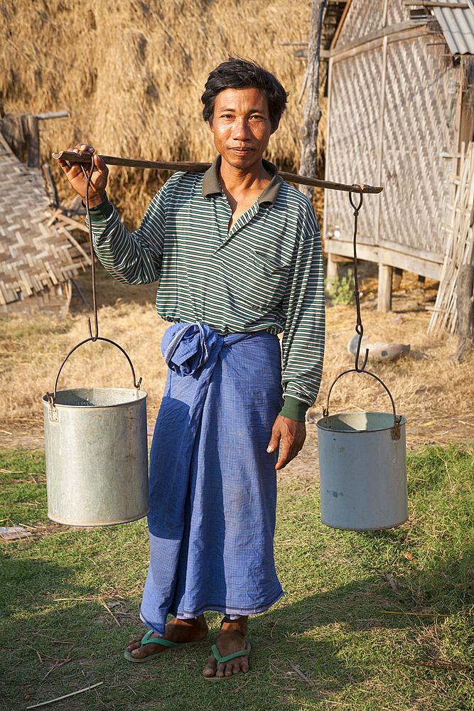 Man carrying pannier for water, Yay Kyi village, Mandalay, Myanmar, (Burma)