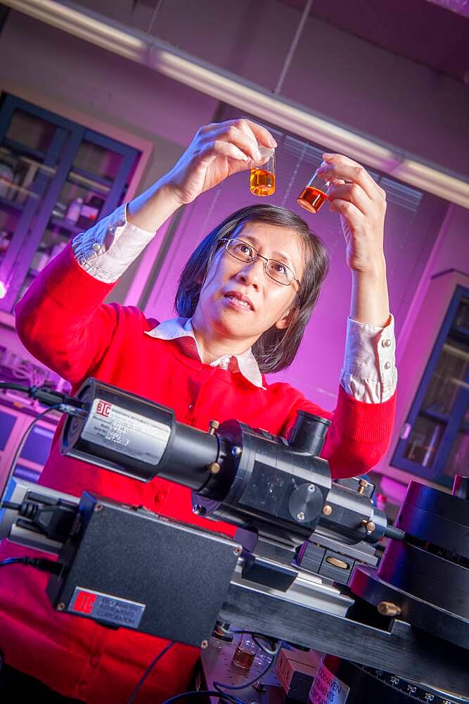 Scientist in Lab, holding up vials of liquid