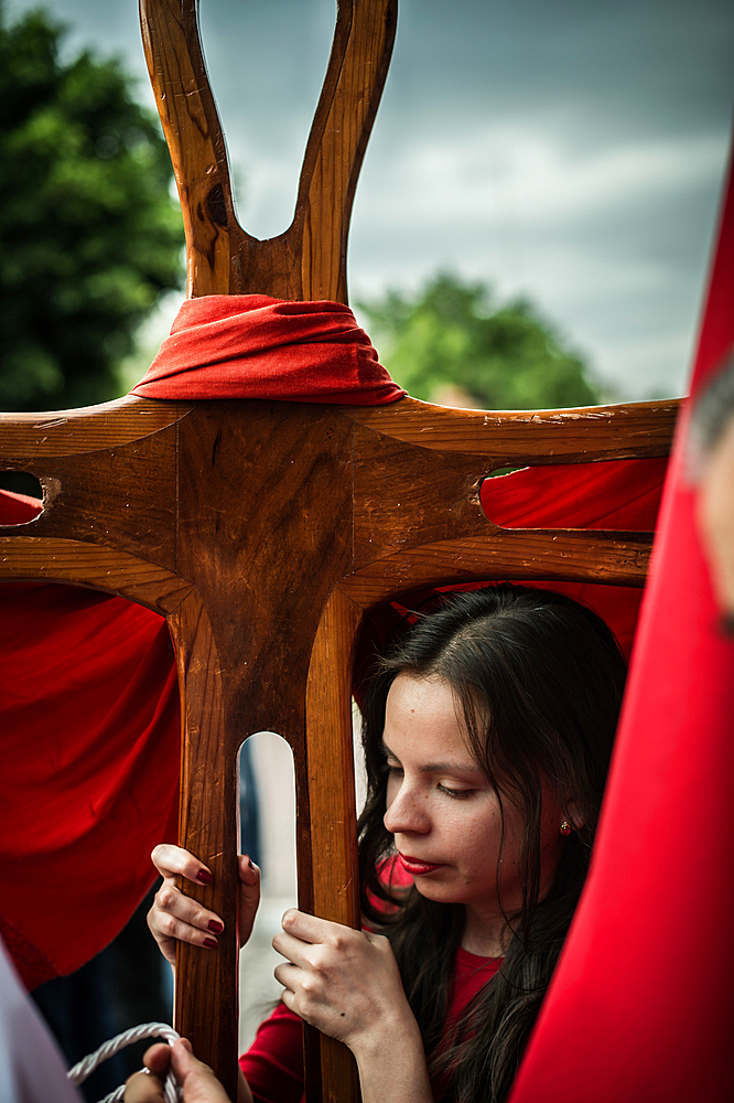 Young woman holding a cross,