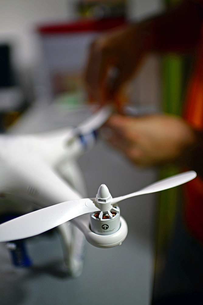 Young man mounting propeller blades on Phantom Drone