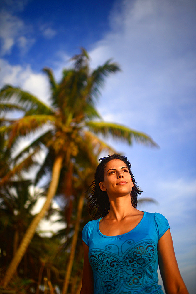 Young woman walking on Hikkaduwa beach at sunset, Sri Lanka