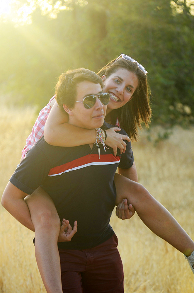 Young man carries girl on her back