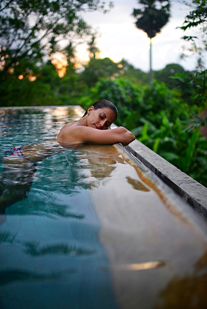 Young attractive woman enjoying a bath in the infinity edge swimming pool at The Dutch House, Galle, Sri Lanka