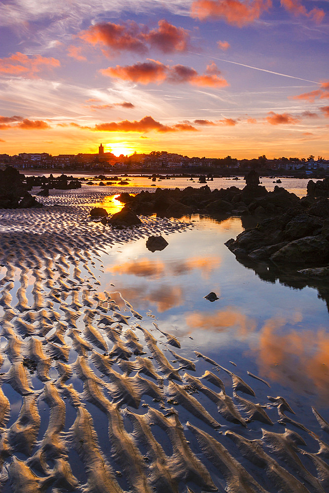 Rocky beach and village at dusk. Trengandin beach. Noja, Cantabria. Spain, Europe.