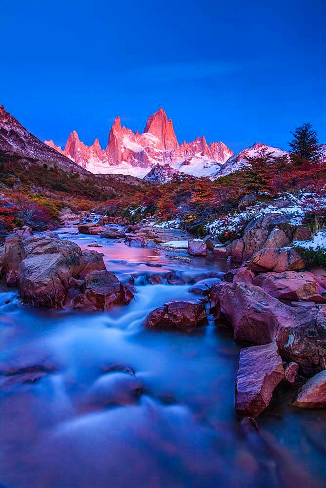 The Fitz Roy Massif in pastel pre-dawn morning twilight.   Los Glaciares National Park near El Chalten, Argentina.  A UNESCO World Heritage Site in the Patagonia region of South America.  Mount Fitz Roy is in the tallest peak in the center.  The creek in the foreground is the Arroyo del Salto.