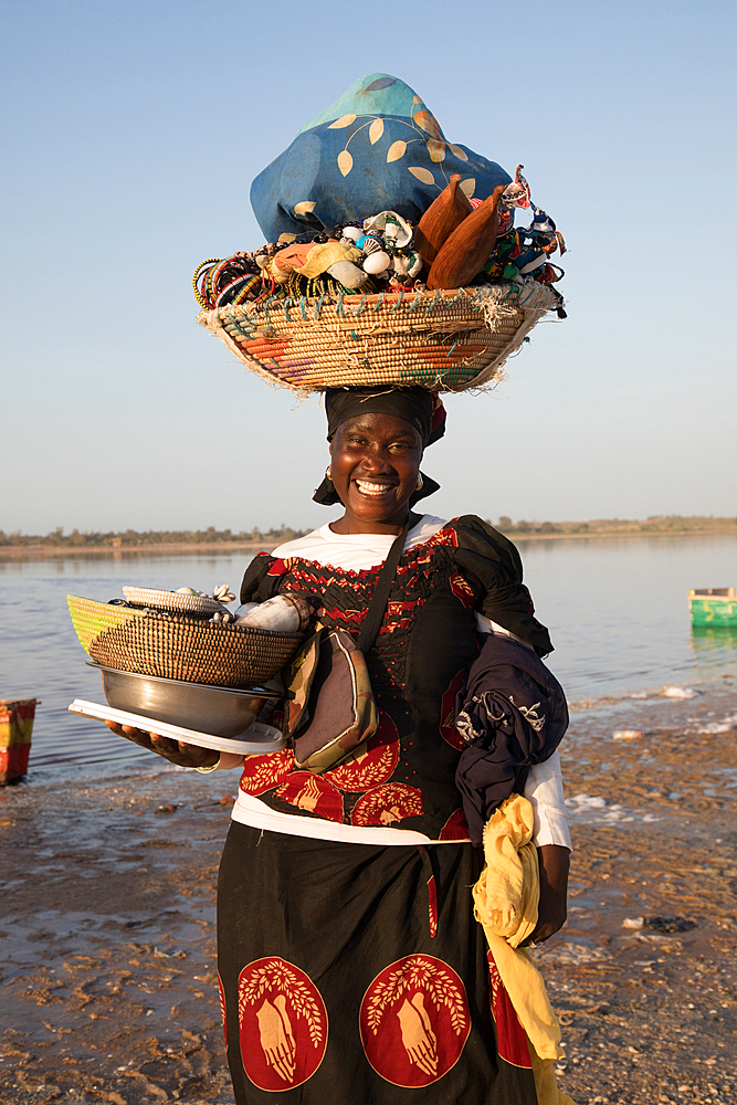 Fitou carrying her wares on the shores of Lac Rose or Lake Retba in Senegal