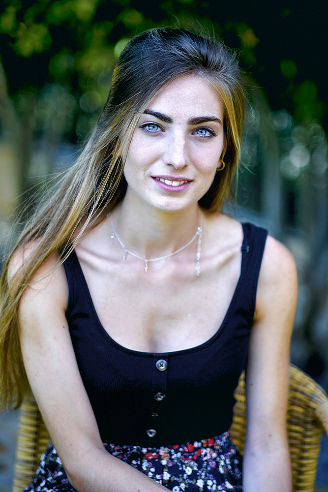 Natural beauty portrait of young woman in her 20´s with long hair and blue eyes outdoor in a garden. Lifestyle concept.