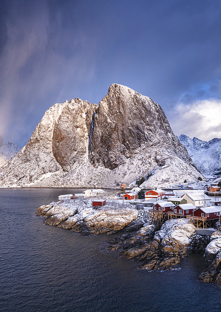 Red Norwegian Rorbuer Huts and Festhaeltinden mountain in winter, Hamnoy, Moskenes Municipality, Nordland County, Lofoten Islands, Norway, Scandinavia, Europe