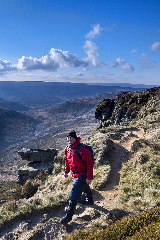 Walker on the Pennine Way at Laddow Rocks backed by Crowden Great Brook valley, Peak District National Park, Derbyshire, England, United Kingdom, Europe