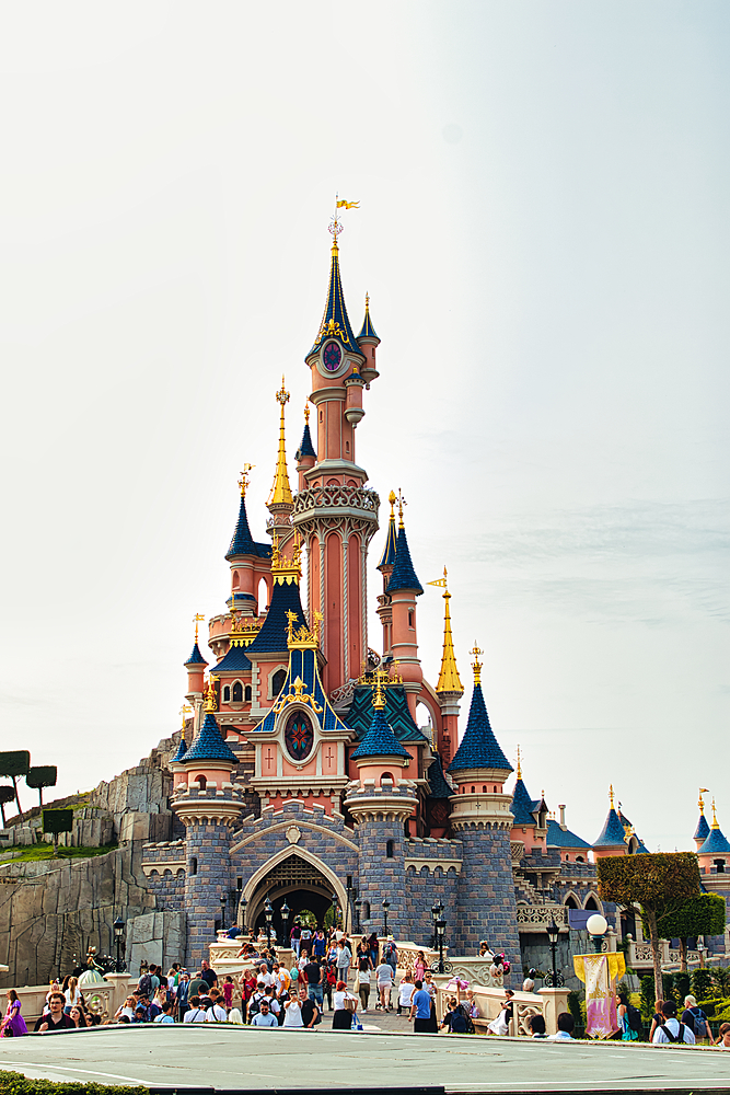 Full shot of Sleeping Beauty castle in Disneyland Paris, crowded with people on a sunny day at Disneyland Paris, France.