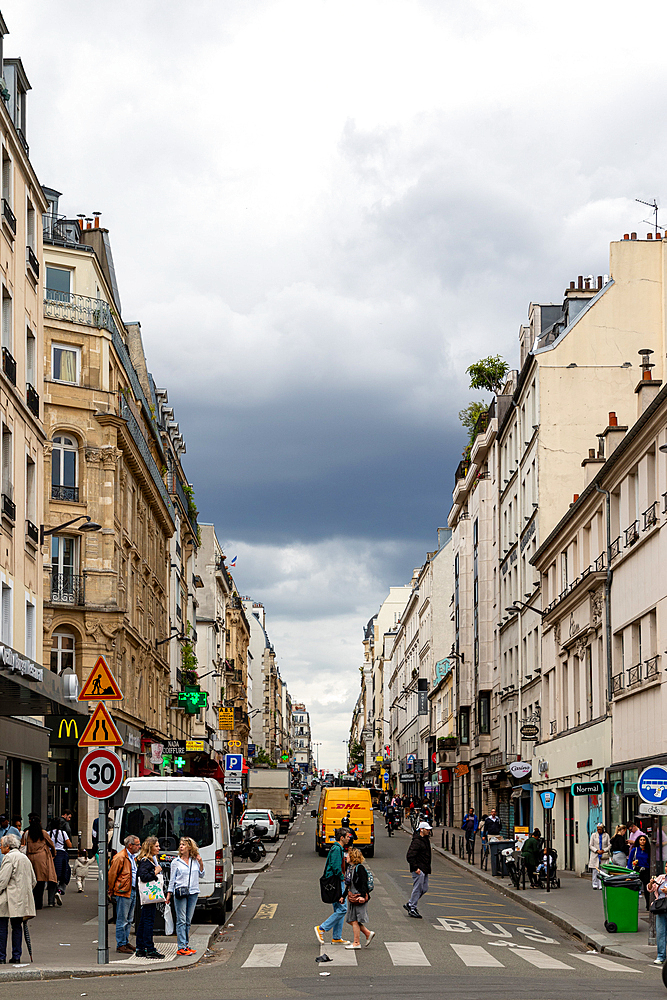 A street view showcases Parisian buildings, pedestrians, vehicles, and a cloudy sky, captured from street level.
