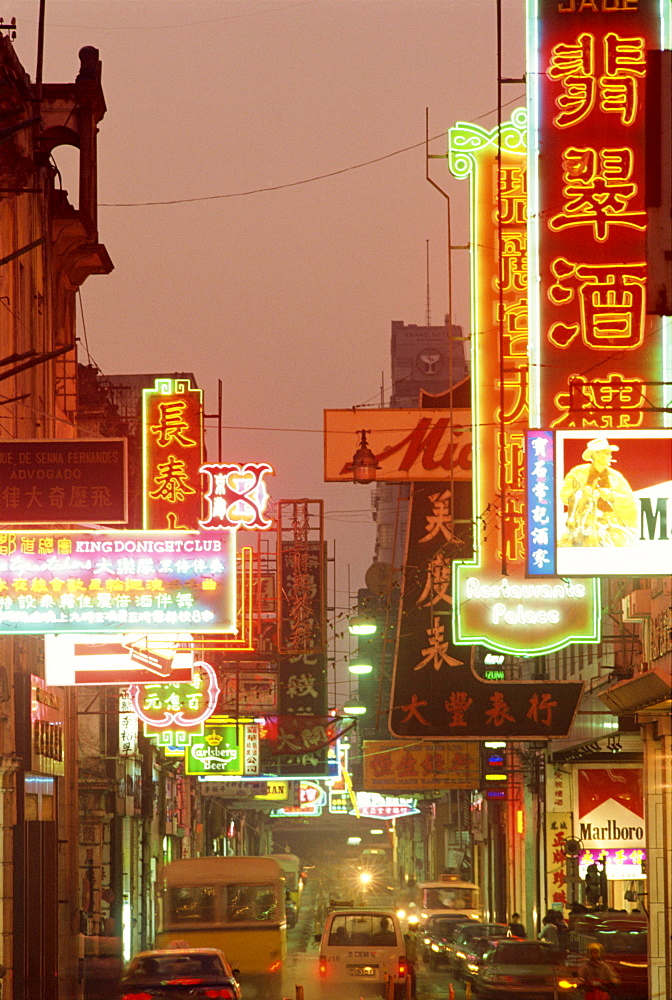 Traffic and neon signs in the evening on Avenida Almeida Ribeiro in Macau, China, Asia